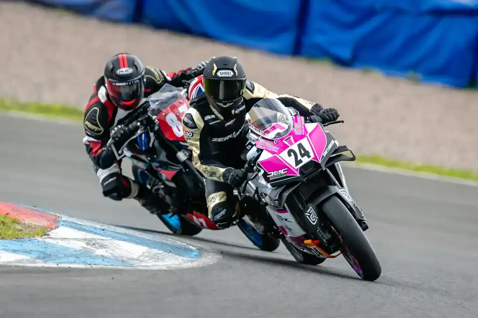 Evan Brailsford leaning the number 24 Zero To One Racing KTM 990 RC R through a corner, leading another rider, at Knockhill.