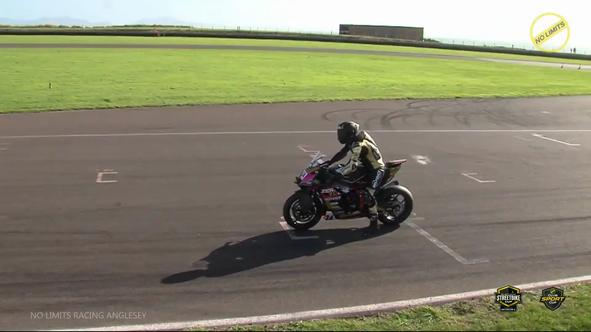 RND 8 Anglesey Coastal 4 NLR TV broadcast still of Evan Brailsford stopped in his grid box on the number 24 KTM 990 RC R after the Race 23 warm-up lap at Anglesey. Links to the race on YouTube.