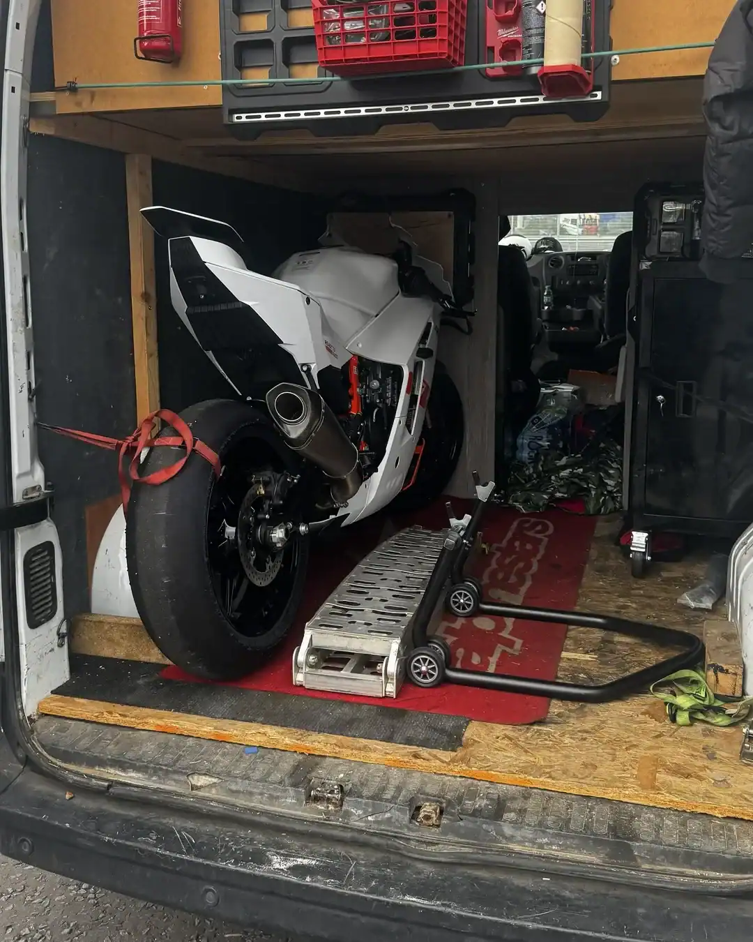 KTM 990 RC R Acquisition and New Livery 2 The KTM 990 RC R strapped into the back of a van, with a paddock stand and loading ramp in front of it.